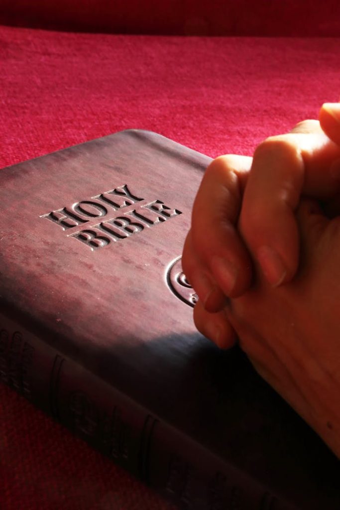 pexels-photo-267559 Close-up of hands praying on a Holy Bible, symbolizing faith and spirituality.